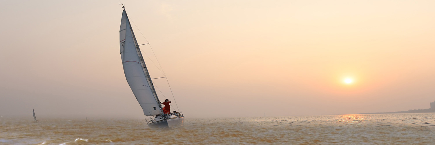 Sailboat on open water in warm evening light